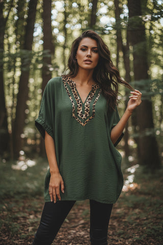 A women wearing an olive green top with leopard print