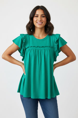 Woman wearing a green blouse with ruffled sleeves on a white background