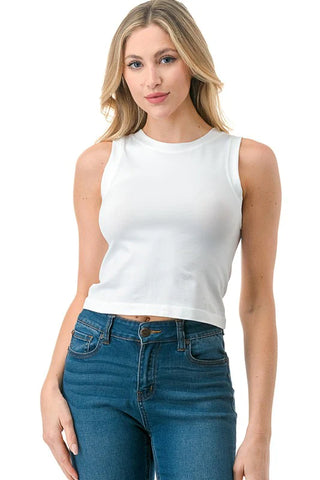 Woman wearing a white sleeveless top and blue jeans on a white background