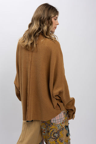 Person wearing a brown oversized shirt with a white background