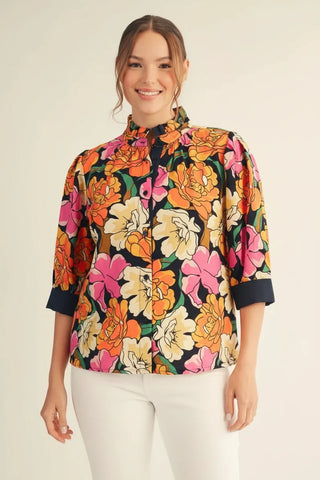 Woman wearing a colorful floral blouse with a plain background