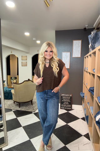 Woman standing in a store with checkered floor and shelves in the background