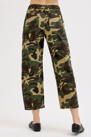 Camouflage pants worn by a person on a white background