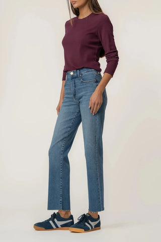 Person wearing a maroon sweater and blue jeans on a white background
