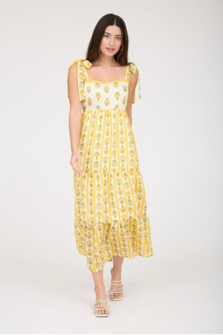 Woman wearing a yellow floral dress on a white background