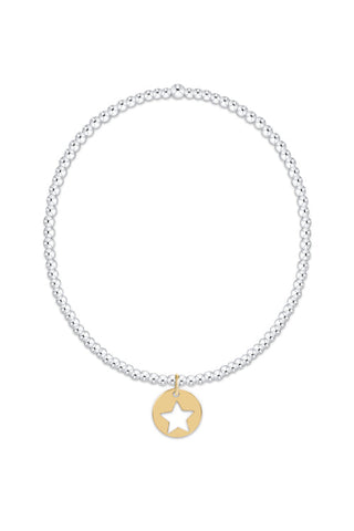 A delicate silver chain necklace with a small gold star-shaped pendant, centered on a plain white background.