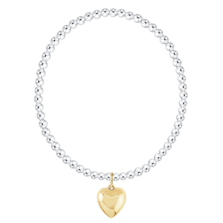 Silver beaded bracelet with a gold heart-shaped charm on a white background