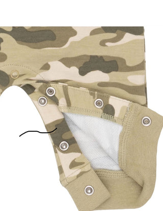 Close-up of a baby garment with a beige, green, and brown camouflage pattern, featuring metal snap closures and a white inner lining.