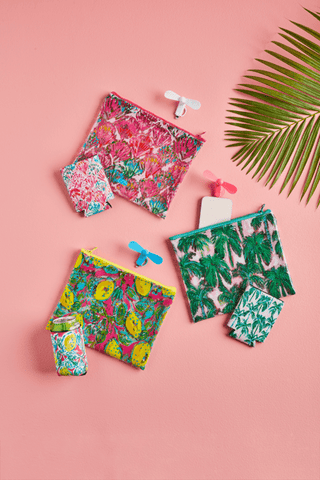 Colorful tropical-themed beach pouch set on a pink background with palm leaves.