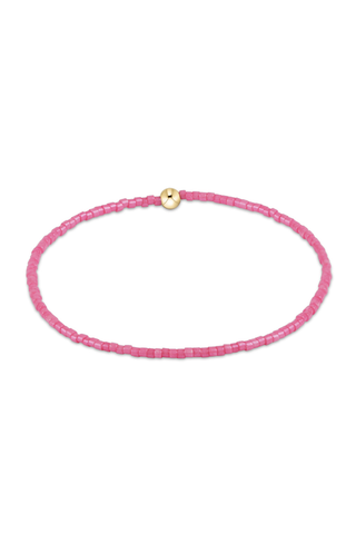 Pink beaded bracelet with a gold clasp on a white background