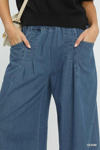 Person wearing blue denim pants with a plain background