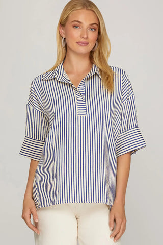 Woman wearing a blue and white striped shirt against a plain background