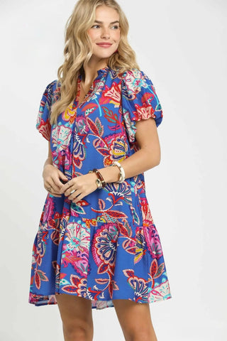 Woman wearing a colorful floral dress on a white background