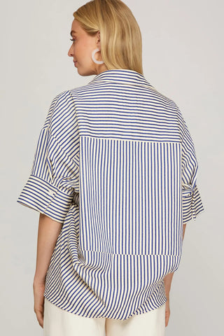 Woman wearing a blue and white striped shirt against a plain background