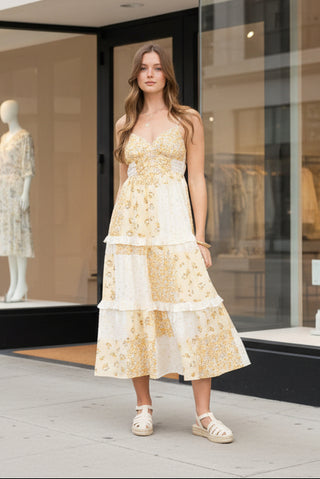 Woman wearing a yellow floral dress standing next to a boutique glass window