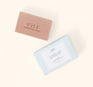 Two rectangular soap bars in pastel packaging on a warm cream background. The top bar is dusty pink with gold foil text reading 'FHF FARMHOUSE FRESH'.