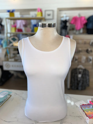 White tank top on a mannequin bust with a blurred store background