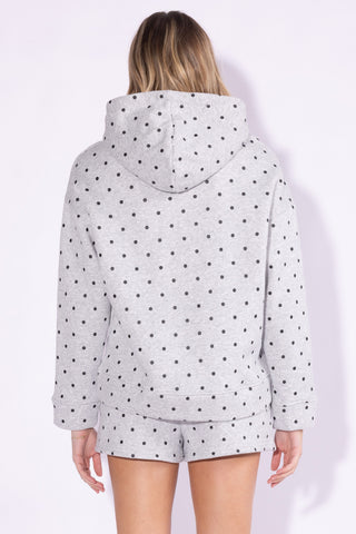 A woman shown from the back wearing a light gray hooded sweatshirt and matching shorts, both covered in a black polka dot pattern, against a plain light background.