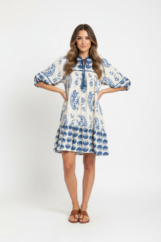 Blue and white floral dress on a hanger in a clothing store.