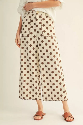 Polka dot pants worn by a person on a plain background
