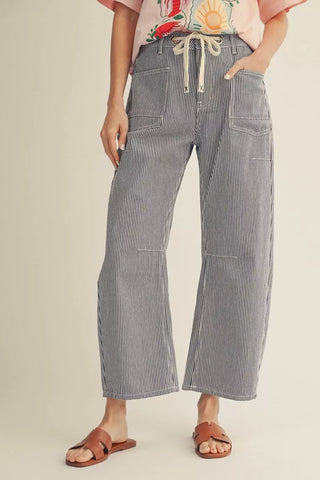 Person wearing blue striped pants on a beige background