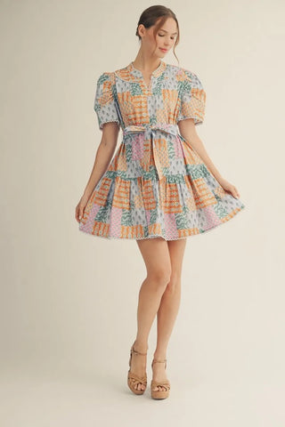 Woman wearing a colorful patterned dress on a beige background
