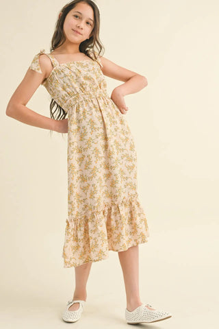 Young girl wearing a floral dress on a beige background