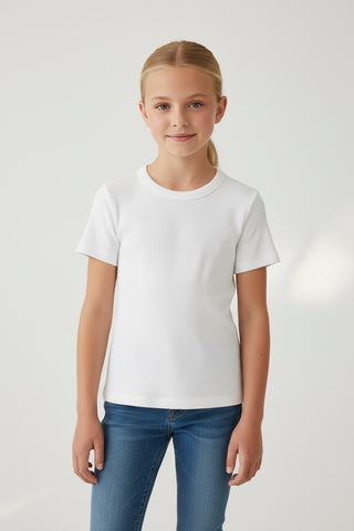 Young girl wearing a plain white t-shirt and blue jeans on a light gray background