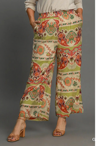 Colorful patterned pants worn by a person on a gray background