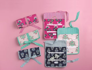 Set of colorful fabric bags on a pink background