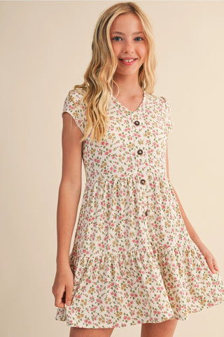 Young girl wearing a floral dress against a beige background