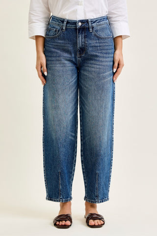 Person wearing blue jeans and a white shirt on a plain background