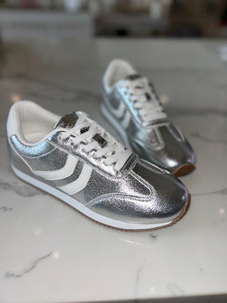 Silver and white sneakers on a marble surface