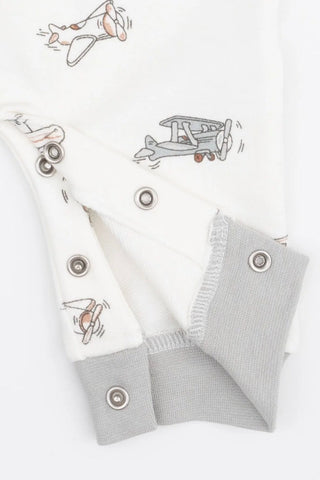 White baby romper with gray and brown airplane illustrations, featuring gray ribbed cuffs and silver snap buttons.
