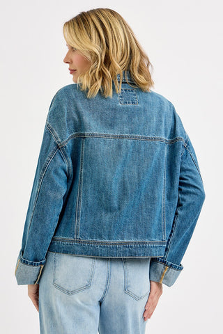 Person wearing a blue denim jacket on a white background