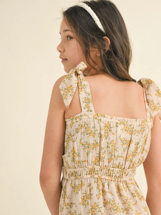 Young girl wearing a floral dress with a plain background