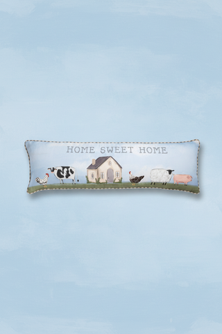 Decorative pillow with farm animals and 'Home Sweet Home' text on a blue background