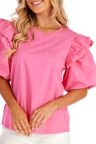 Woman wearing a pink blouse with ruffled sleeves on a white background