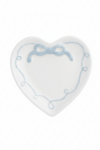 White heart shaped ring dish with blue bow design on white background