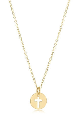Gold necklace with a round pendant featuring a cross on a white background
