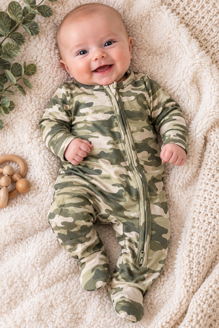 Baby wearing the camo footie laying on a blanket. 