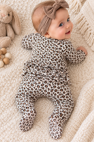 Baby laying on her tummy wearing footie showing ruffles on bottom, 