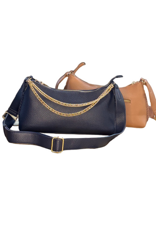 Navy and Dusty Rose handbags with gold accents on a wooden table