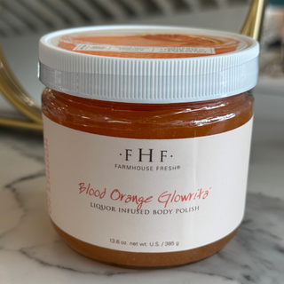 Jar of Farmhouse Fresh Blood Orange Glowrite body polish on a marble surface