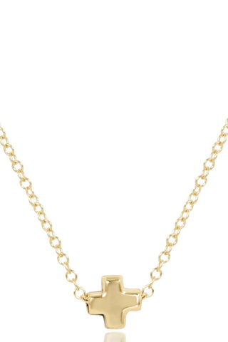 Gold cross necklace on a white background