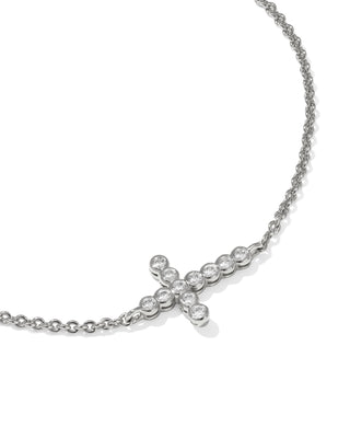 Silver bracelet with a small cross pendant on a white background
