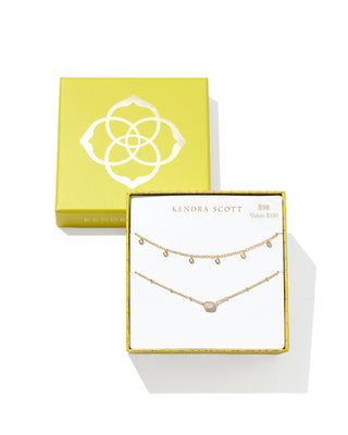 Kendra Scott Mini Elisa and Amelia Chain Necklace Gift Set featuring two delicate gold-tone necklaces, one with a pink oval stone pendant and the other with dangling crystal accents, displayed in a yellow branded gift box. Marked $98 with a $120 value.