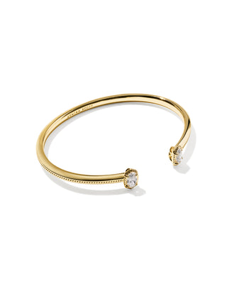 A polished gold cuff bangle bracelet with two oval clear gemstone settings, shown on a clean white background.