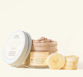 Jar of banana-based skincare product with slices of banana on a white background