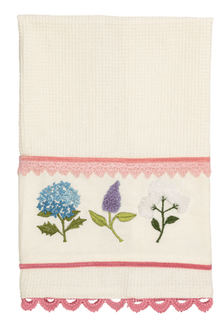 Decorative towel with floral embroidery and pink lace trim on a white background